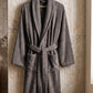 Soft white cotton Turkish bathrobe from TORK, shown hanging with a plush texture and cozy design.