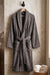 Soft white cotton Turkish bathrobe from TORK, shown hanging with a plush texture and cozy design.