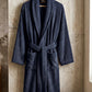 White cotton Turkish bath towel from TORK with intricate traditional patterns, displayed folded on a wooden surface.
